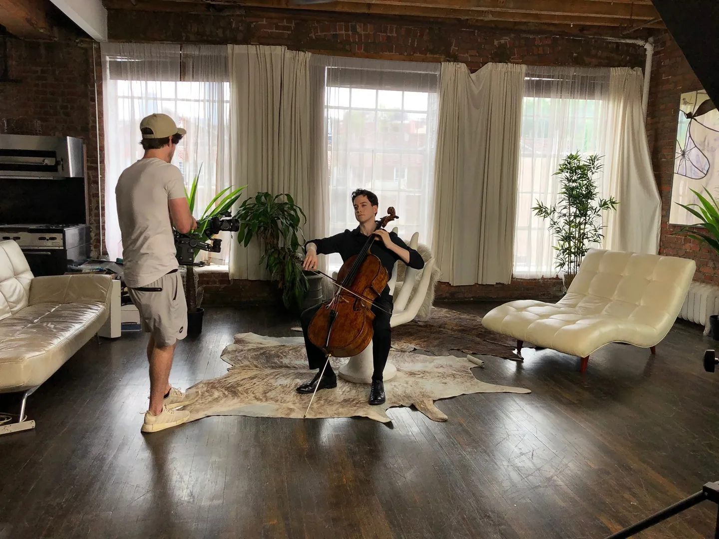 Behind the scenes: a music videographer filming a cellist in a loft with big windows